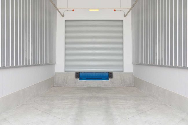 Concrete loading dock with dock leveler